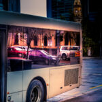Autos spiegeln sich in einer Busscheibe, Abendstimmung