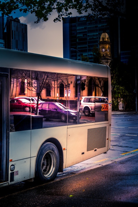 Autos spiegeln sich in einer Busscheibe, Abendstimmung